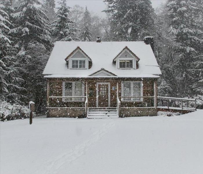 home in winter with snow falling